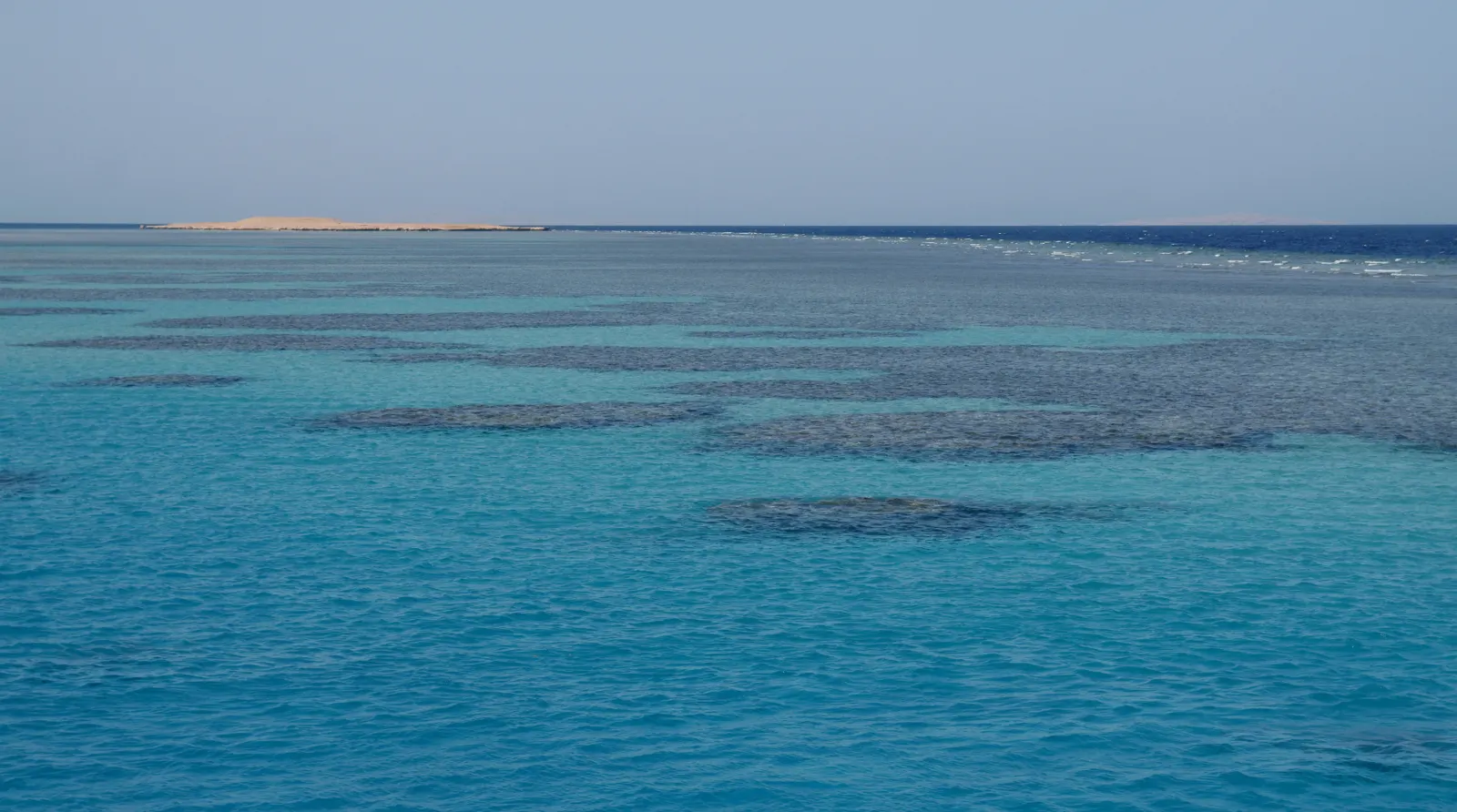 Dark reef shapes beneath turquoise water near Hurghada